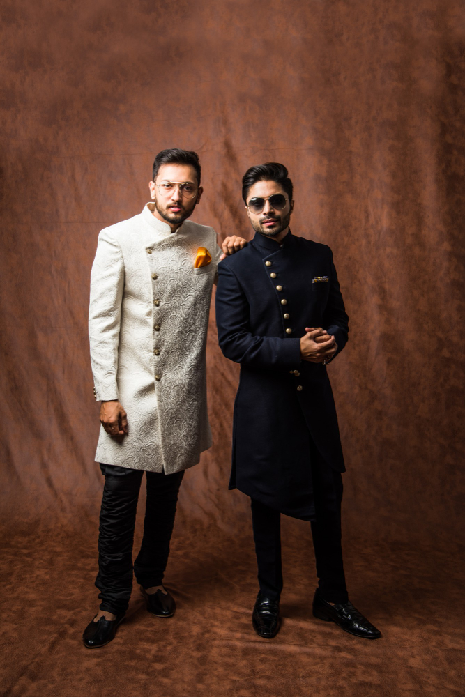 two-indian-men-wears-ethnic-traditional-cloths-male-fashion-models-with-sherwani-kurta-pyjama-sitting-posing-wing-chair-sofa-against-brown-grunge-background-selective-focus